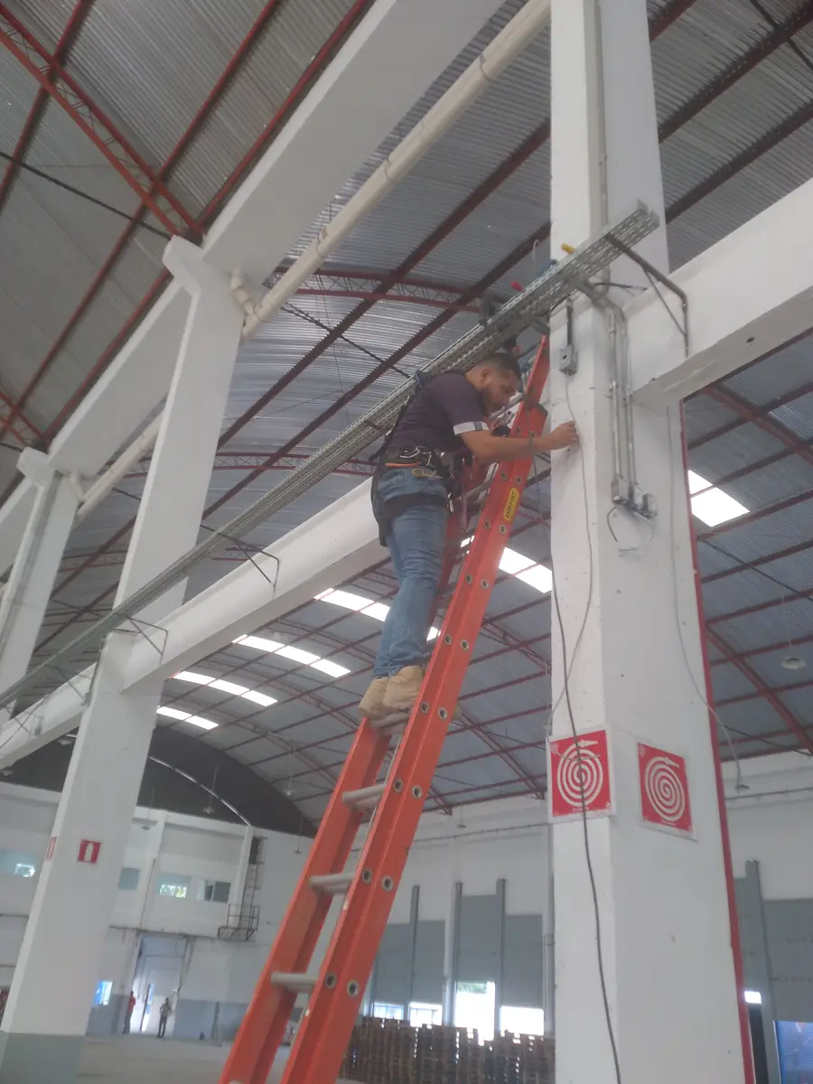 Técnico da Keleuthos instalando infraestrutura de cabeamento em galpão industrial
